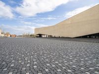 an empty courtyard is shown in this picture with a building that has many windows and some buildings