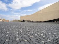 an empty courtyard is shown in this picture with a building that has many windows and some buildings