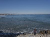 surfers are in the ocean waiting for waves to break on their stomachs as they head towards shore