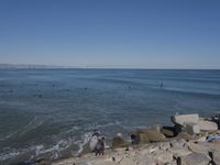 surfers are in the ocean waiting for waves to break on their stomachs as they head towards shore