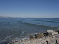 surfers are in the ocean waiting for waves to break on their stomachs as they head towards shore