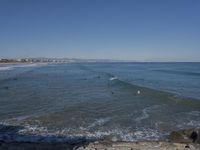 surfers are in the ocean waiting for waves to break on their stomachs as they head towards shore