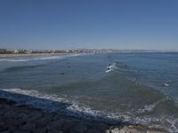 surfers are in the ocean waiting for waves to break on their stomachs as they head towards shore