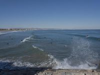 surfers are in the ocean waiting for waves to break on their stomachs as they head towards shore