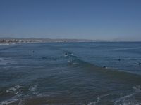 surfers are in the ocean waiting for waves to break on their stomachs as they head towards shore