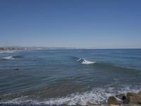 surfers are in the ocean waiting for waves to break on their stomachs as they head towards shore