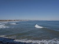 surfers are in the ocean waiting for waves to break on their stomachs as they head towards shore