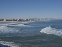 surfers are in the ocean waiting for waves to break on their stomachs as they head towards shore