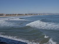 surfers are in the ocean waiting for waves to break on their stomachs as they head towards shore