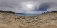 a panoramic view of a beach with cliffs and sea in the background, from a low angle