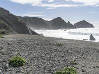 a view of the beach at low tide on the coast near the rocky cliffs and water