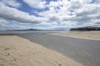 a deserted beach with an ocean view next to it, and one person walking toward the water