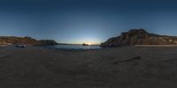 an 360 - pan picture taken at sunset on the beach with rocky formations in front