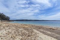 there is a sandy beach that is on the beach with lots of sand and stones