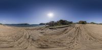 a photo taken from the beach of a skate boarder on the sand with an ocean and island in the background