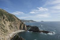 an ocean is seen with rocky shoreline and the water below it, with waves coming in from the ocean and rocks on either side