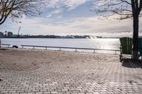 a bench and chair sitting on the curb by the water with benches to sit and watch