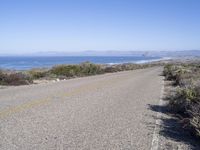 a bicycle lies in the middle of a road near the ocean and desert in california