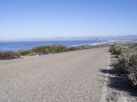 a bicycle lies in the middle of a road near the ocean and desert in california