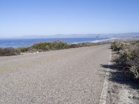 a bicycle lies in the middle of a road near the ocean and desert in california