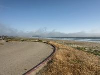 a fire hydrant near a paved beach with a long winding road in the foreground