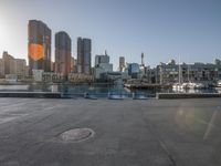 the sun shines brightly on the waterfront in the cityscape of sydney with boats and skyscrapers