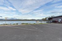 a lake area with a large boat dock and a building in the background and blue skies overhead