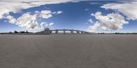 an image of a panorama with the bridge going over it in the distance as clouds fill the sky