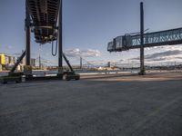 two large cranes are near a freeway in an industrial area that is being built for a transportation