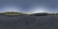 there is a fisheye image of a man riding his skateboard on the boardwalk