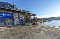 a boathouse sits along the shore with a sign on it saying surf bay shop