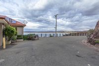 there is a picnic table near the lake with a bench beside it and power poles