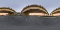 a view of two oval shaped bridge on a road at sunset while viewed from below