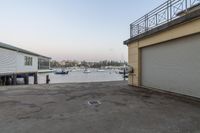 garage parking lot with boats in harbor next to building with balcony overhead view with clear sky