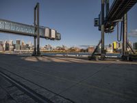 a couple of trains ride down the tracks near a bridge above a city skylines