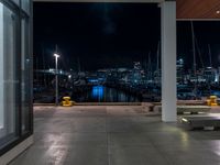 a large concrete deck with benches and a view of the city lights in the background