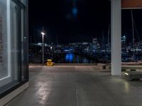 a large concrete deck with benches and a view of the city lights in the background