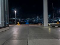 a large concrete deck with benches and a view of the city lights in the background