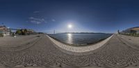 some fisheye looking photos of an outdoor setting and a body of water with buildings, a bridge, and a large body of water