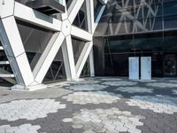 an open walkway outside a very modern building made of bricks and steel strips in a city