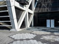 an open walkway outside a very modern building made of bricks and steel strips in a city