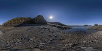 fisheye lens, taken above the beach of a rocky shoreline with rocks and water