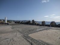 the street is full of concrete barriers and small rocks surrounding it on the shore of an ocean