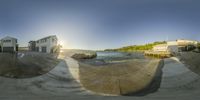 a skate board park has a view of the water and shore with a few buildings