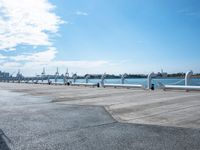 a parking lot with parked airplanes on the side of it and the ocean in the background