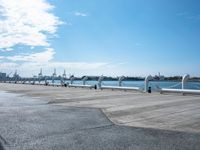 a parking lot with parked airplanes on the side of it and the ocean in the background