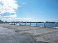 a parking lot with parked airplanes on the side of it and the ocean in the background