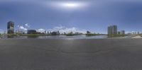 the view from the skateboard ramp across the empty area, toward a skyscraper and waterway