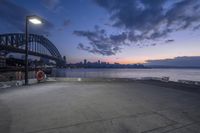 a photo taken from the pier showing an early sunset sky in the background and a boat docked next to the dock