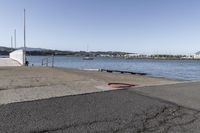 the boardwalk is leading towards the water to a pier next to some boats on the beach